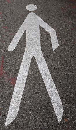 painted road sign, attention pedestrians, white shape of a walking man on grey tarmacの写真素材