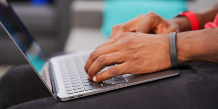 Close up of male hands while typing on laptop