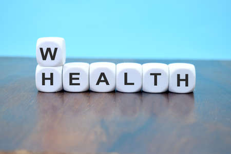 cubes showing the word health and wealth at the same time symbolizing to keep the balanceの写真素材