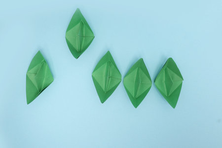 Business competition concept with Green paper ships on white backgroundの写真素材