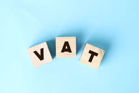 VAT concept for taxes and fees. Wooden alphabet cubes . Selective focus. Value added taxの写真素材