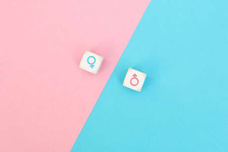 Male and female sex icons on cubes on pink and blue background. Sex change, gender reassignment, transgender and sexual identity concept.の写真素材