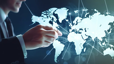 Man hand clicks on abstract graphic digital world map with connections on blurred office background, globalization conceptの素材