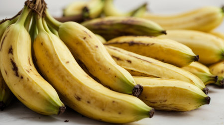 Bunch of bananas on a white marble background. Selective focus.の素材