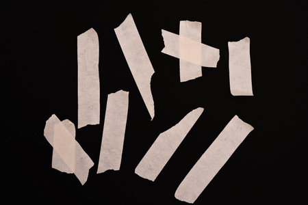 pieces of torn paper on a black background, note shallow depth of field
