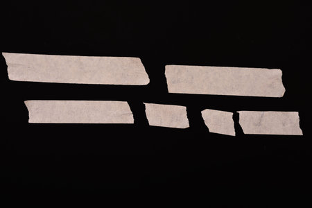 pieces of torn paper on a black background, closeup of photo