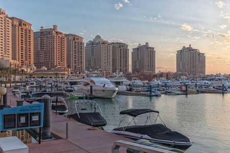 Doha,Qatar-January 25,2020:  The pearl Marina daylight view with Yachts in foreground, buildings and clouds in the sky in backgroundのeditorial素材