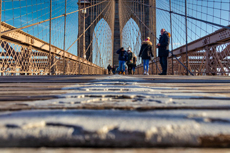 New York, USA-December 20, 2019: Brooklyn Bridge daylight view low angle shot with people walking on...