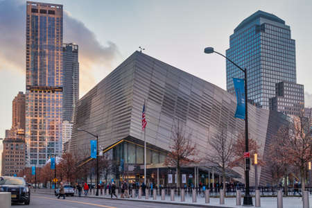 New York, USA-December 19, 2019: The National September 11 Memorial & Museum (9/11 museum) daylight exterior view with people and cars in the street and clouds in the sky in backgroundのeditorial素材