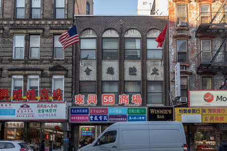 New York City, USA - December 20, 2019:Chinatown neighborhood in Lower Manhattan NYC daylight view showing shops in the street with  Chinese letters ,symbols and people walkingのeditorial素材