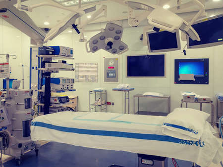 Operating theater  (room) in a modern hospital interior shot with bed in the middle and anesthesiology equipment. no peopleの写真素材