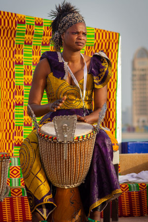 Portrait of African drummer lady wearing Traditional tribe costume with blurred background shot...