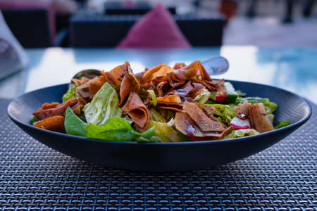 Fattoush (Lebanese salad) close up  image in a blue plate . It is made with vegetables and crispy toasted flatbread, which soaks up the dressing beautifully.の写真素材