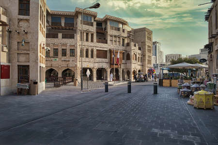 Souq waqif in Doha Qatar daylight view showing traditional Arabic architecture , Qatar flag and people in the streetのeditorial素材