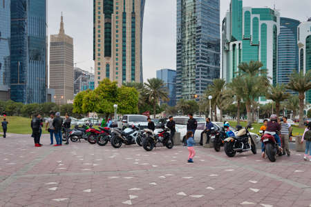 Sheraton park in Doha Qatar afternoon shot with people enjoying the park, Doha skyline and clouds in sky in backgroundのeditorial素材