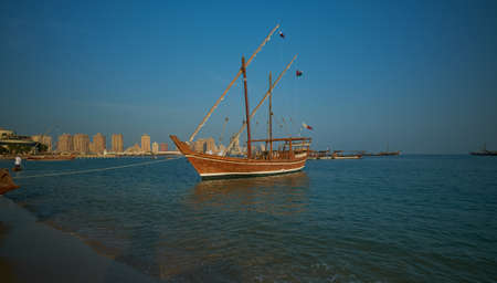 dhows with Qatar Flag in Arabic gulf in Katara eleventh traditional dhow festival in Doha Qatar sunset shotのeditorial素材