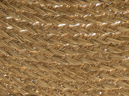 Detail of the inside of a woven straw beach umbrella with the sky showing through the gaps