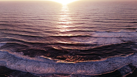 Sunset Drone View of Layered Ocean Waves with Pink Reflectionsの写真素材