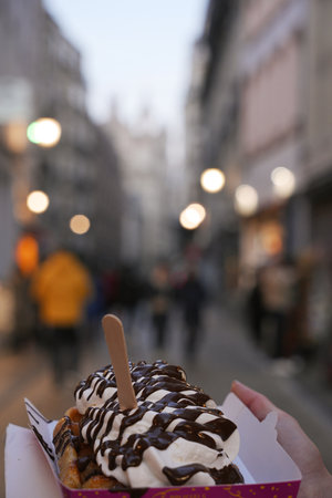 Belgian Waffle with Chocolate and Cream Held on Busy Brussels Streetの写真素材