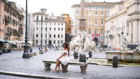 Woman in white dress near fountain Piazza Navona Romeの写真素材