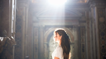 Woman admiring Roman church interior with soft natural light
