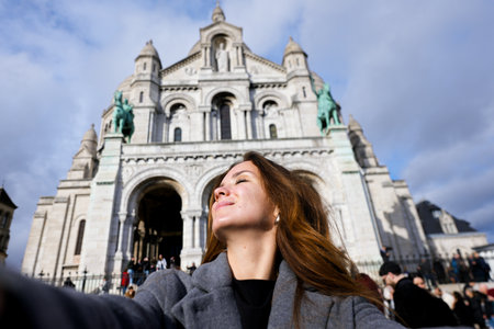 Smiling woman taking selfie in front of Sacre Coeurの写真素材