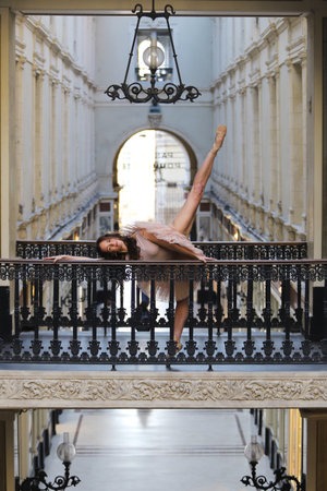 Graceful ballerina performing dance pose in historic archwayの写真素材
