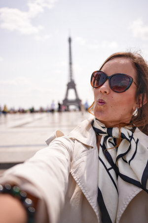 Stylish woman taking selfie near Eiffel Tower in Parisの写真素材