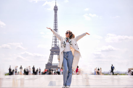 Joyful woman with raised arms near Eiffel Tower in Paris