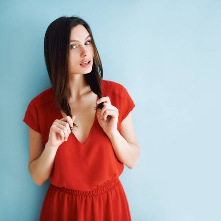 studio portrait of a girl in a red dress. brunette hairの写真素材