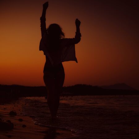silhouette of a girl on a sunset background. travel, vacation conceptの写真素材