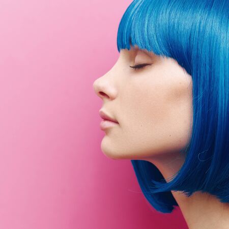 portrait of a beautiful girl on a pink background. Girl with blue hairの写真素材