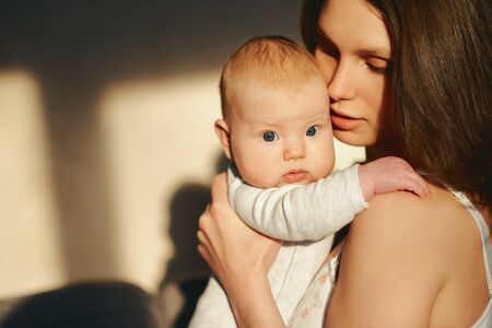 portrait of a woman with a newborn baby in her armsの写真素材
