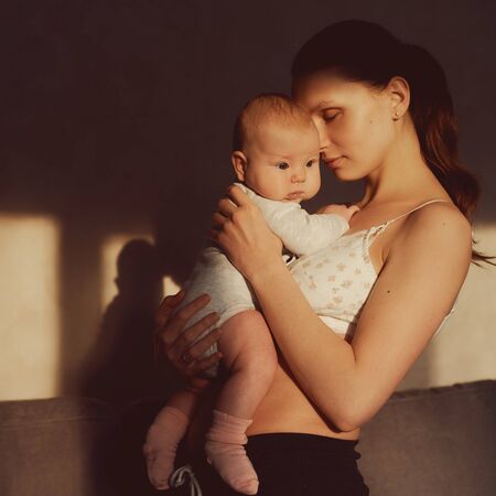 portrait of a woman with a newborn baby in her armsの写真素材