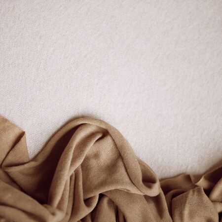 texture of natural crumpled brown fabric on a white background. fine knitting. isolated. place for signature.の写真素材
