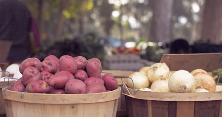Red potatoes and white onions on a wooden bucket in the market. Fresh vegetables open air market...