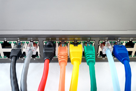 Network Switch with connected colourful network cablesの写真素材