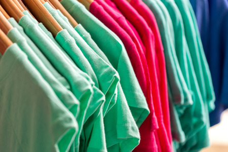 Colorful t-shirts on hangersの写真素材