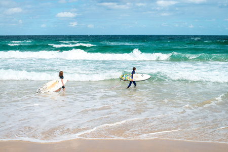 Sydney, Australia - November 8, 2015: Little girl and boy going for surfing at Bondi Beach on a day. Bondi beach is one of the most famous places for surfing in Australiaのeditorial素材