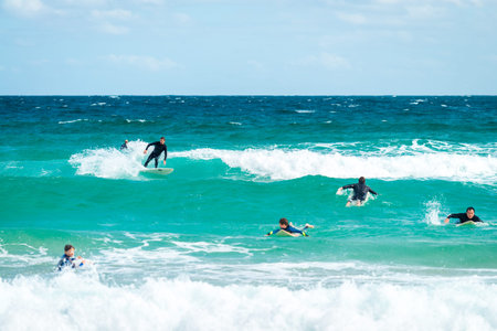 Sydney, Australia - November 8, 2015: Surfers catching the waves in the waters of Bondi Beach on a...
