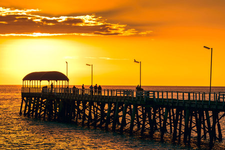 People on Henley Beach Jetty at sunset, South Australia. Color-toning appliedの写真素材