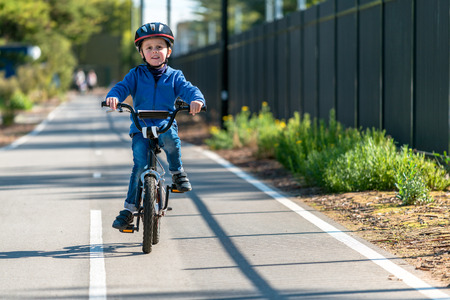 Happy aussie boy riding his bicycle on bike lane on a day, South Australiaの写真素材