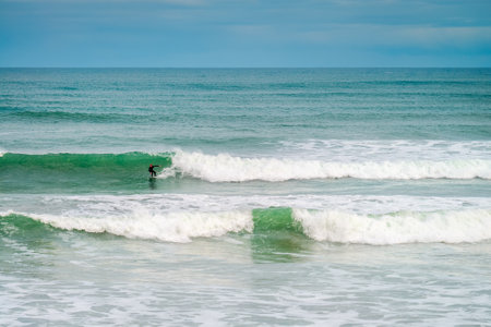 Adelaide, Australia - August 14, 2016: Surfer sliding the wave at Middleton Beach on a day. Middleton beach is one of the most famous places for surfing in South Australiaのeditorial素材