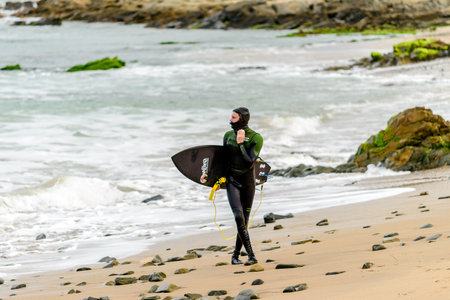 Middleton, Australia - August 14, 2016: Surfer holding his surfing board at Middleton Beach on a day. Middleton is one of the most famous places for surfing in South Australiaのeditorial素材