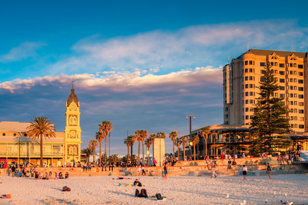 Adelaide, Australia - August 29, 2016: People meeting sunset at Glenelg Beach on a warm evening. Viewed towards Moseley Square and Pioneer memorial.のeditorial素材