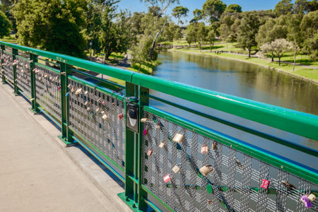 Adelaide, Australia - April 14, 2017: Love locks hooked up to guardrails of Adelaide University Bridge across Torrens river in North Adelaide on a bright dayのeditorial素材