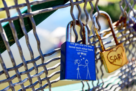 Adelaide, Australia - April 14, 2017: Love locks hooked up to guardrails of Adelaide University Bridge across Torrens river in North Adelaide on a bright dayのeditorial素材