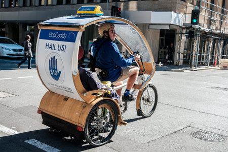 Adelaide, Australia - May 5, 2017: Green eco taxi EcoCaddy tricycle riding with passengers across Pirie Street on a dayのeditorial素材