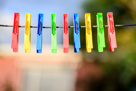 Colorful pegs hanging on clotheslineの写真素材