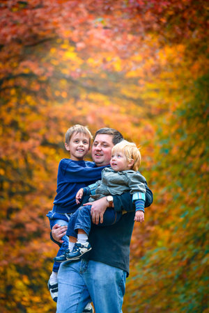 Father walking with his sons in the autumn park, South Australia